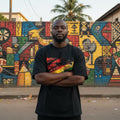 Ghana Black Stars Dark. Man standing in front of a colorful mural with arms crossed