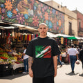 Mexico El Tri Dark Mode. Man wearing a black t-shirt with a colorful design in an outdoor market setting