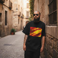 Spain La Roja Dark. Man wearing a black t-shirt with a colorful design in an alleyway.