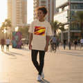 Spain La Roja Sand. Person walking on a city street wearing a white t-shirt with a colorful design.
