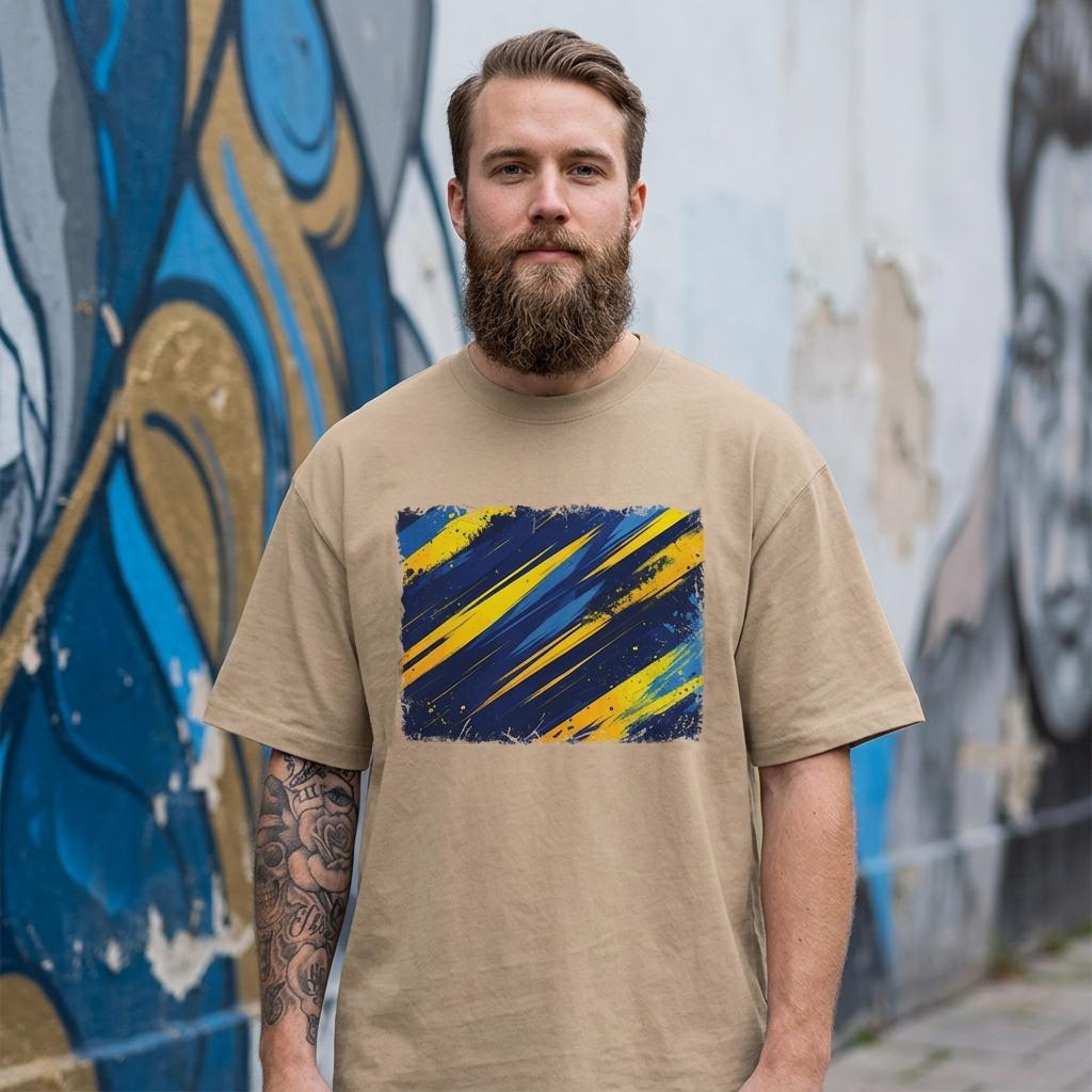 Sweden Blagult Sand. Man wearing a beige t-shirt with a blue and yellow abstract design in front of a graffiti wall.