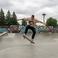 USA Glory Sand Mode. Skateboarder performing a trick at a skate park with graffiti and the Space Needle in the background.
